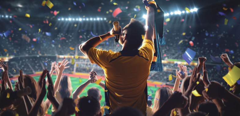Australian rugby fan waving in a crowded stadium at night