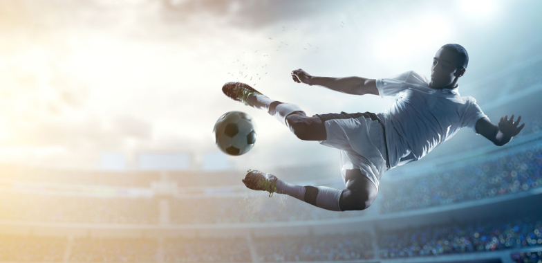 Soccer player in midair going to kick a ball