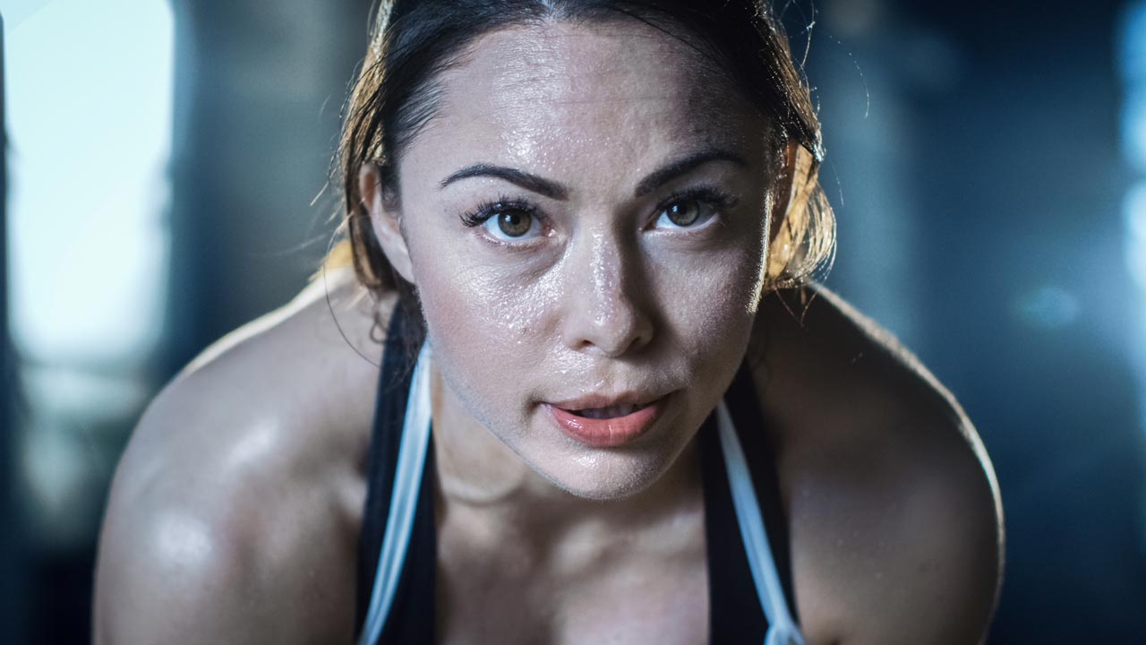 Female athlete close up with intense look during workout