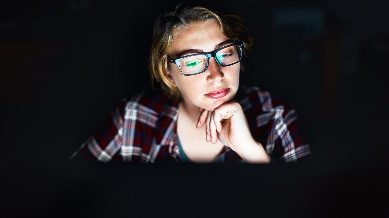 Woman looking at her computer screen smiling