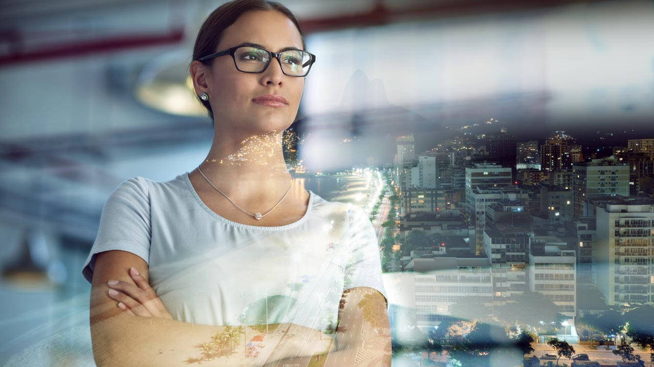 Woman in an office looking though window reflections