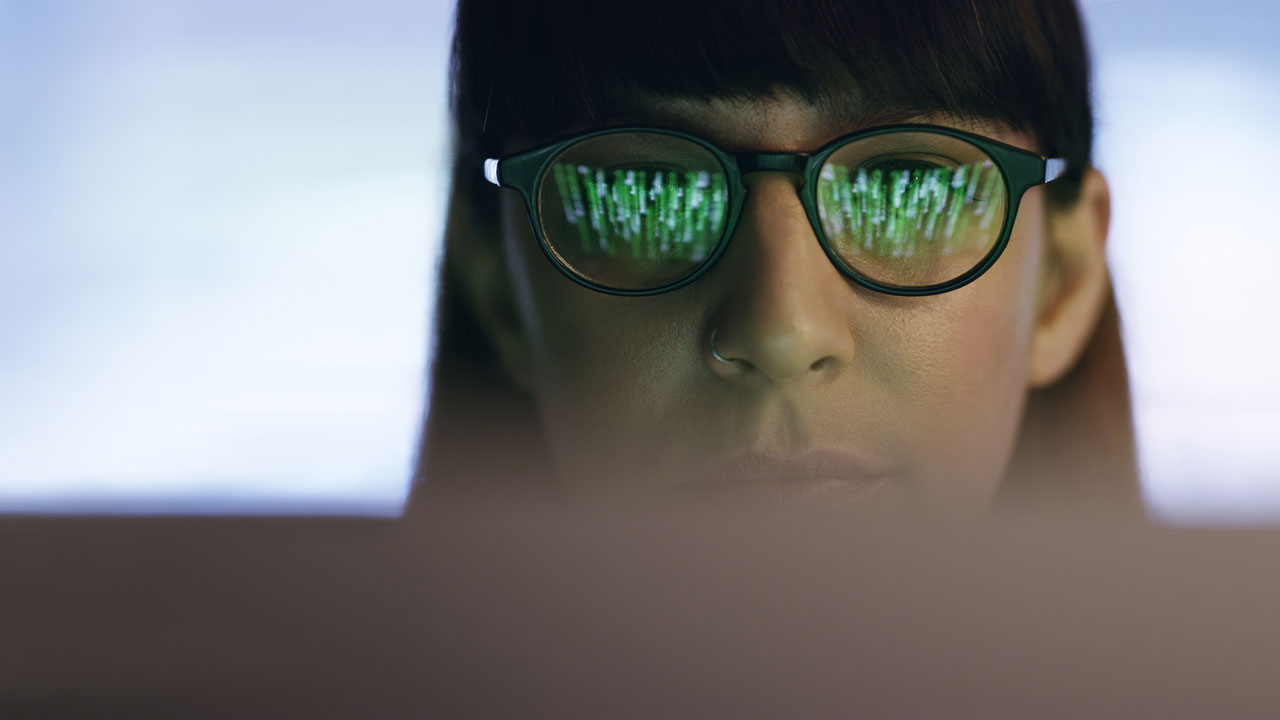 Close up of woman's face wearing glasses looking at a screen