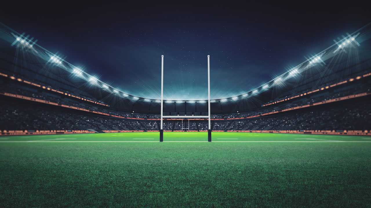 Rugby goal posts in a stadium lit up at night