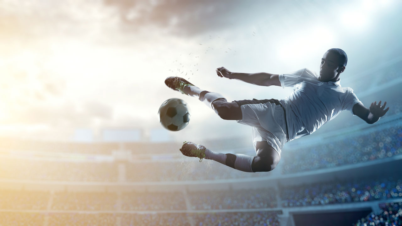 Soccer player in midair going to kick a ball