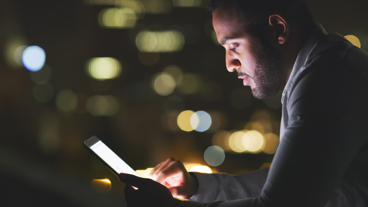 Person looking at their tablet at night