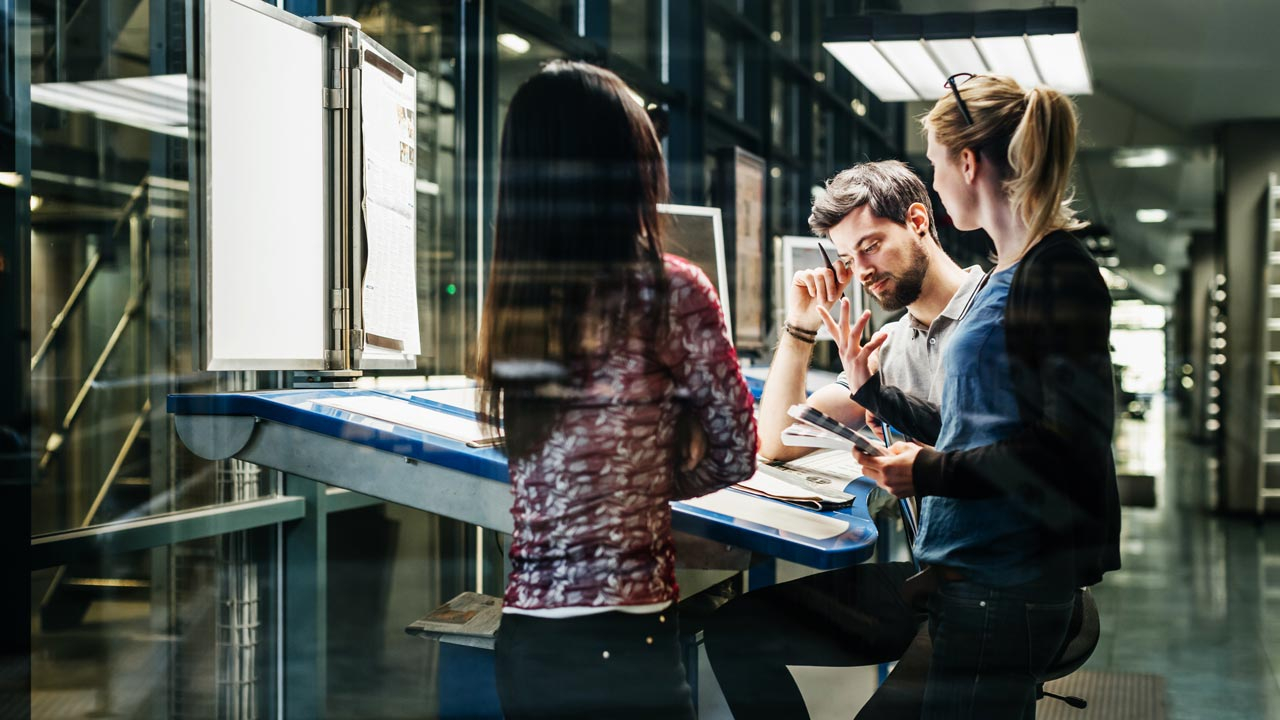 Team of three collaborating over desk